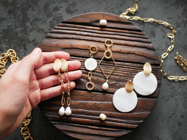 Gold jewelry in hand on a flat lay.