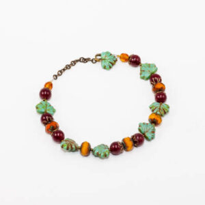 A bracelet made with beads shaped like fruit and leaves.