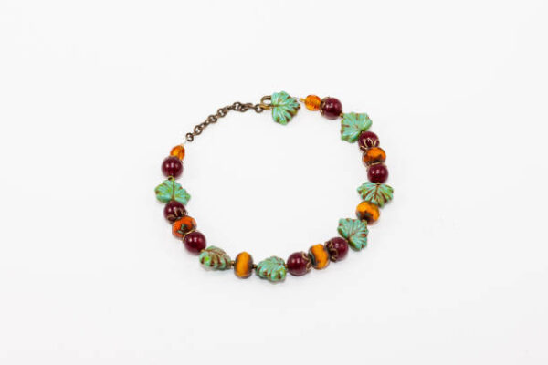 A bracelet made with beads shaped like fruit and leaves.